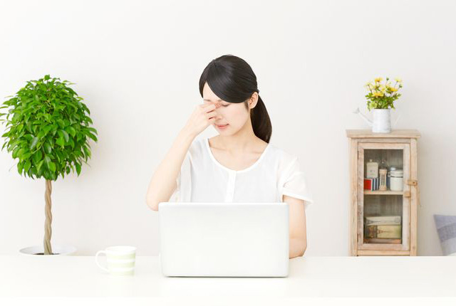 目頭を押さえる女性